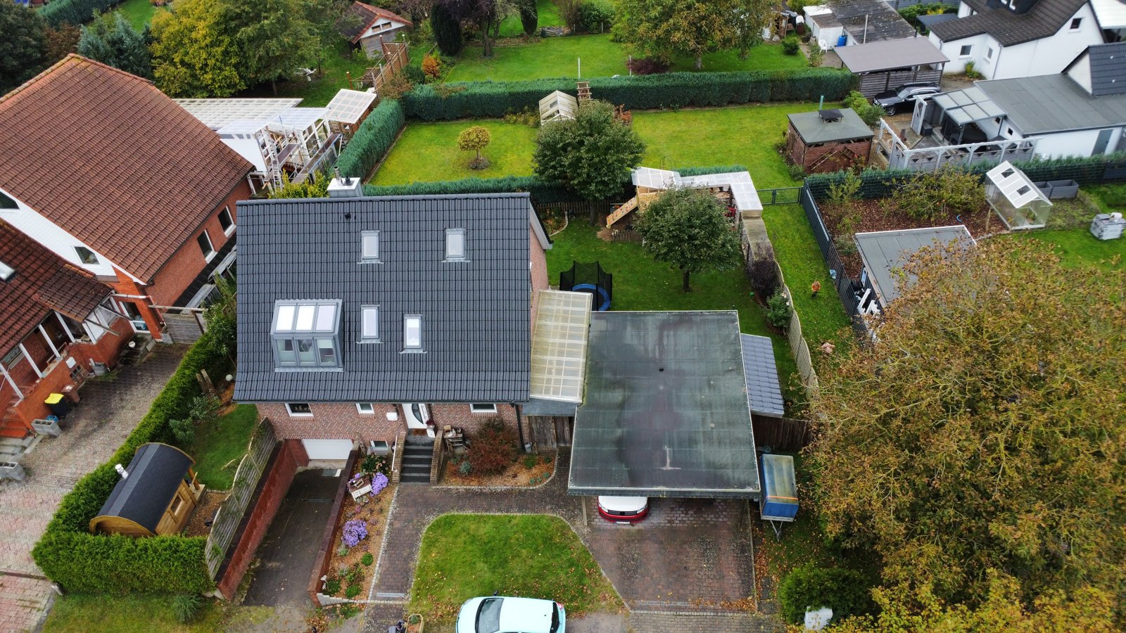 Drohnenaufnahme der Ostseite mit Dachfenstern und angrenzendem Carport